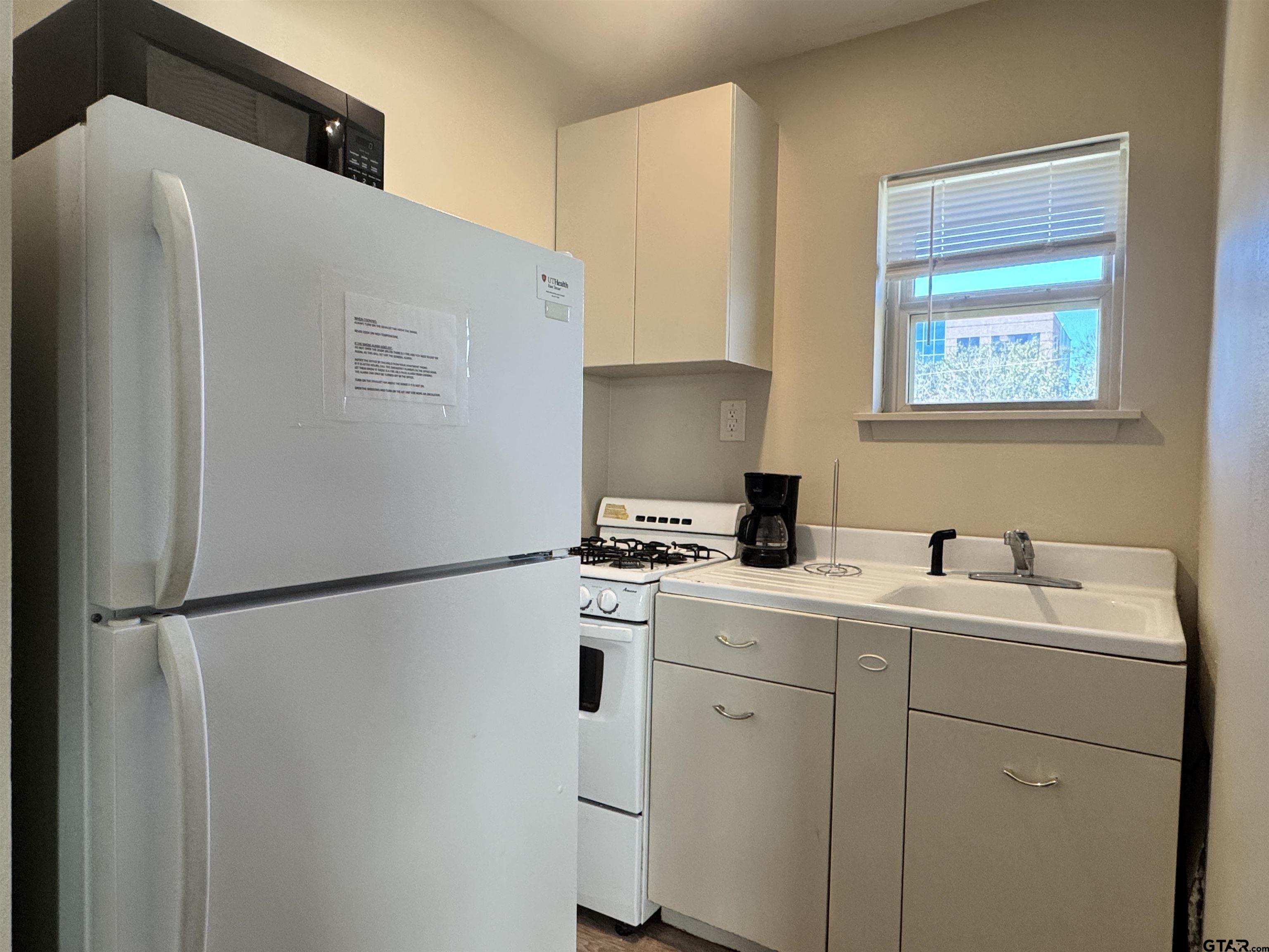 528 South Saunders Avenue Tyler, TX 75702 - Photo 9 of 11 a kitchen with a refrigerator sink stove and cabinets