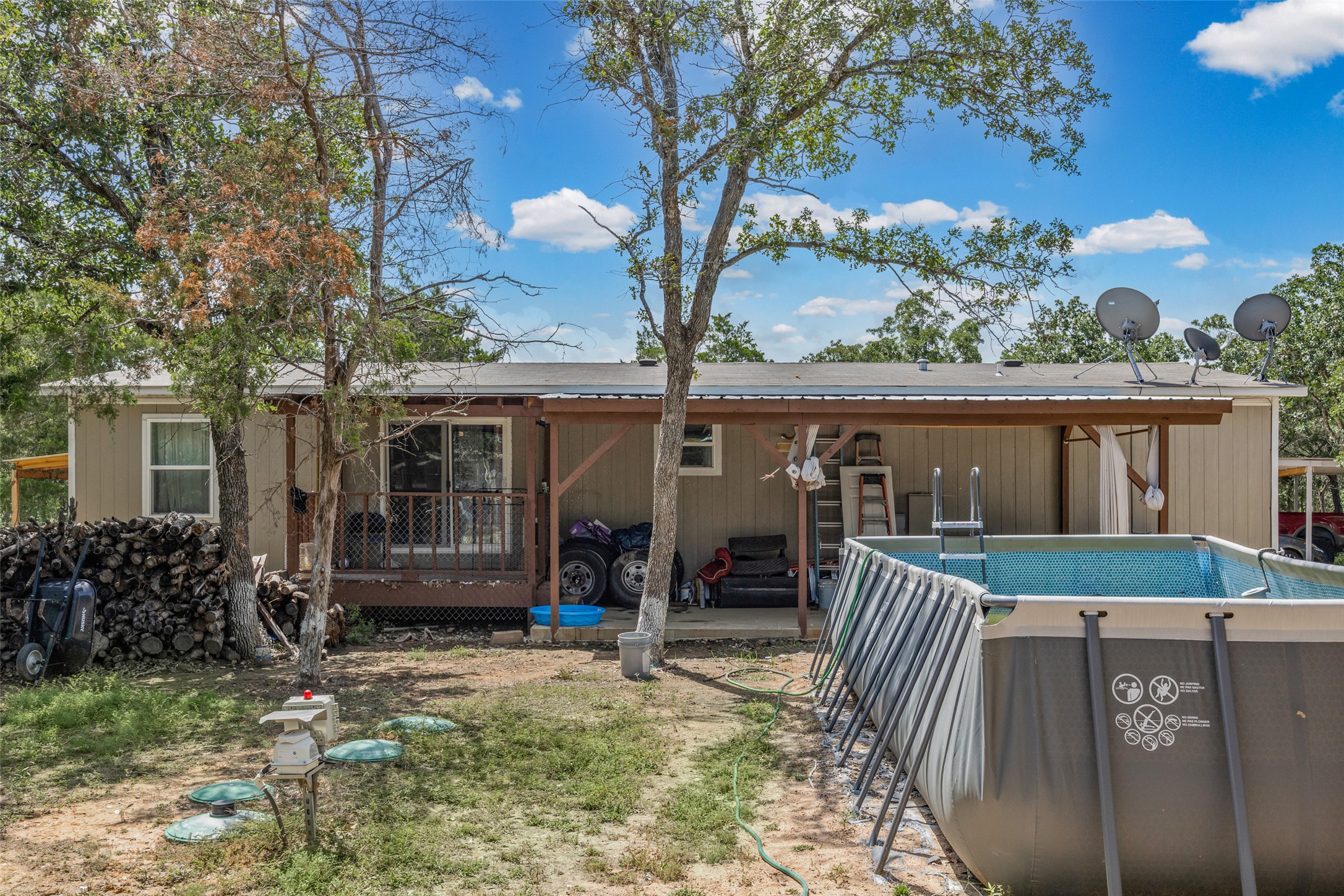 564 Boyd Road Red Rock, TX 78662 - Photo 9 of 25 Discover a tranquil rural setting featuring a covered patio and an inviting above-ground pool, ideal for warm-weather enjoyment.