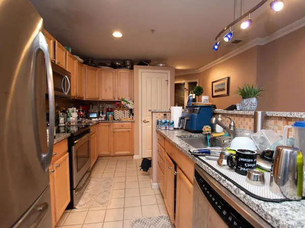 a kitchen with stainless steel appliances granite countertop a stove refrigerator and cabinets