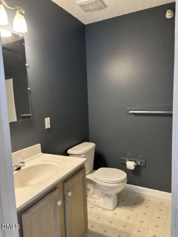 a bathroom with a granite countertop toilet and a sink