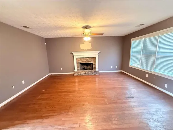 a view of an empty room with a fireplace and a window