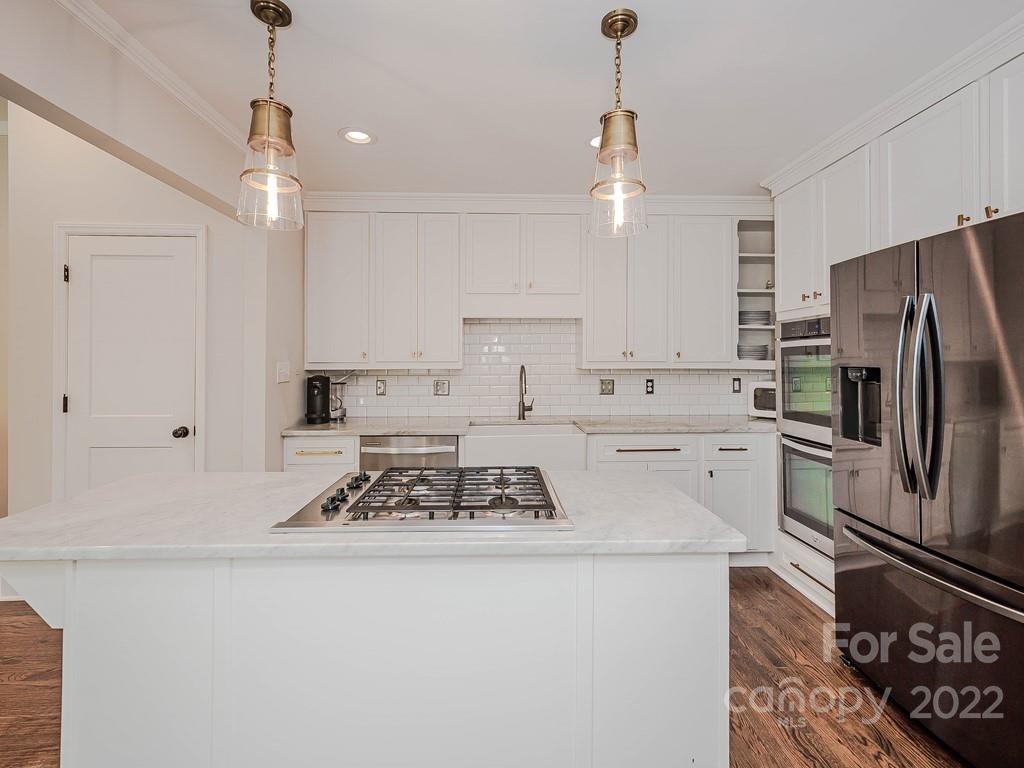 415 Ashworth Road Charlotte, NC 28211 - Photo 10 of 43 a kitchen with stainless steel appliances granite countertop a sink stove a refrigerator and white cabinets with wooden floor