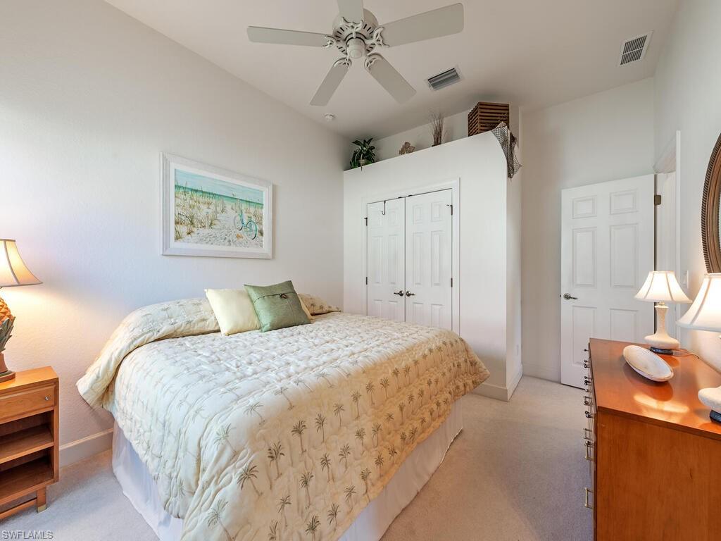 16105 Parque Lane Naples, FL 34110 - Photo 14 of 34 a spacious bedroom with a bed and a chandelier