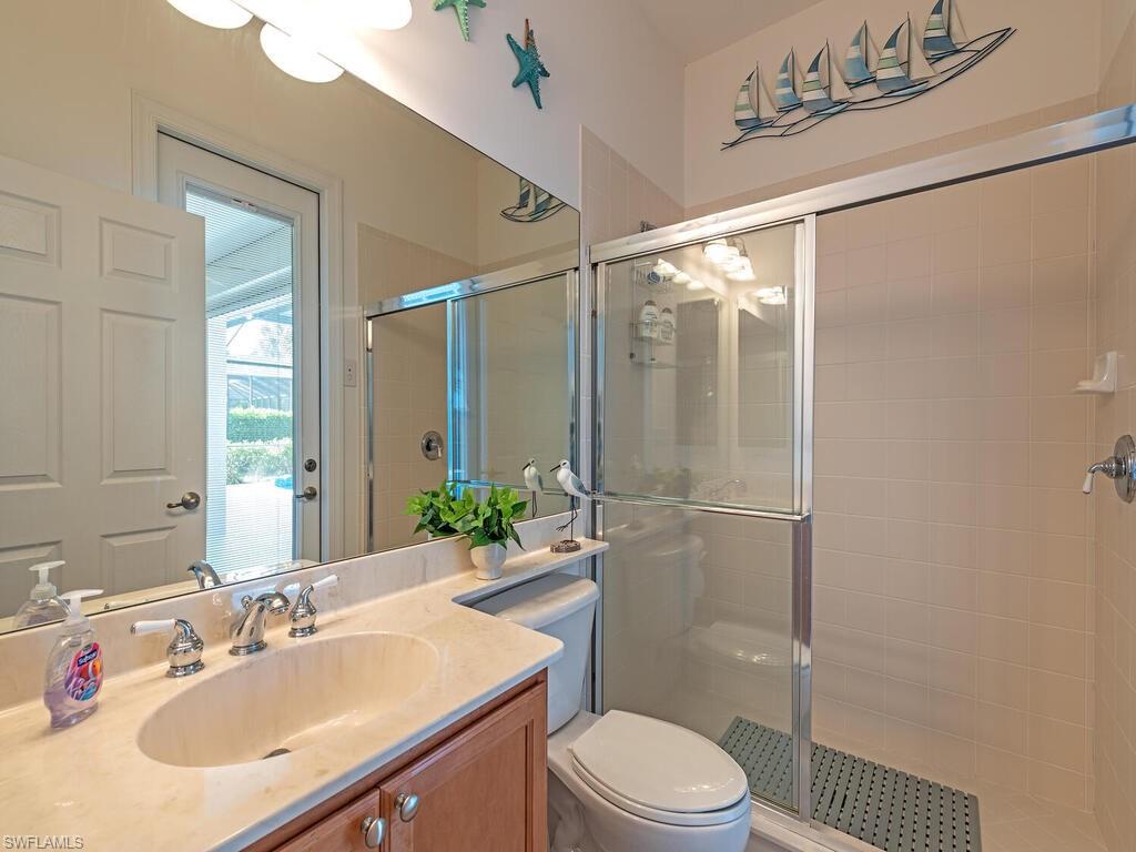16105 Parque Lane Naples, FL 34110 - Photo 15 of 34 a bathroom with a sink toilet and shower