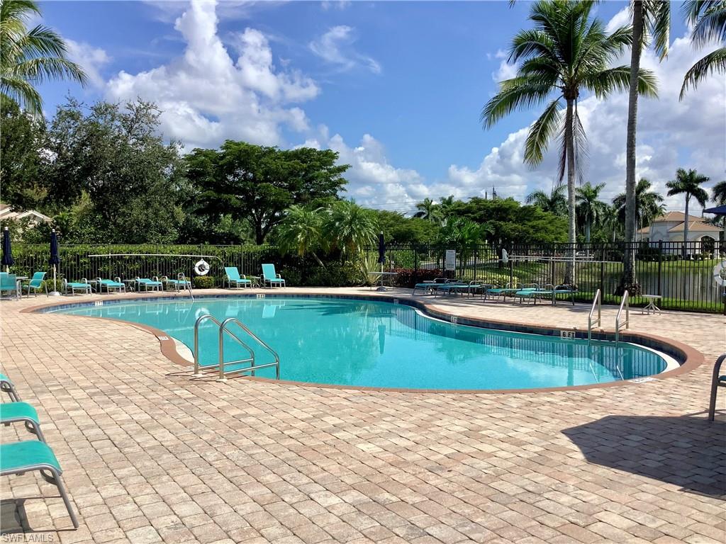 16105 Parque Lane Naples, FL 34110 - Photo 24 of 34 a view of a swimming pool with a yard and palm trees