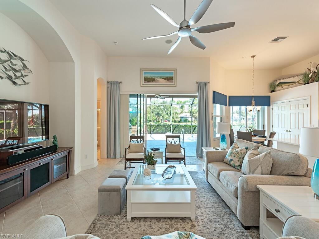 16105 Parque Lane Naples, FL 34110 - Photo 3 of 34 a living room with furniture a large window and a flat screen tv