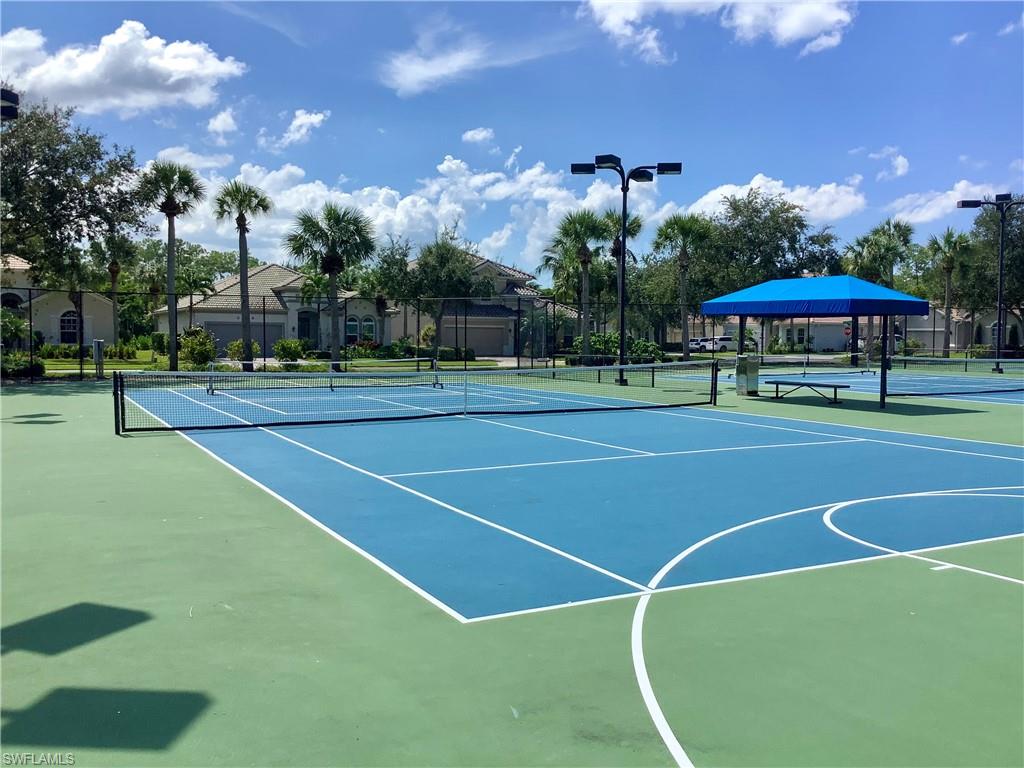 16105 Parque Lane Naples, FL 34110 - Photo 31 of 34 a view of a tennis ground with large trees