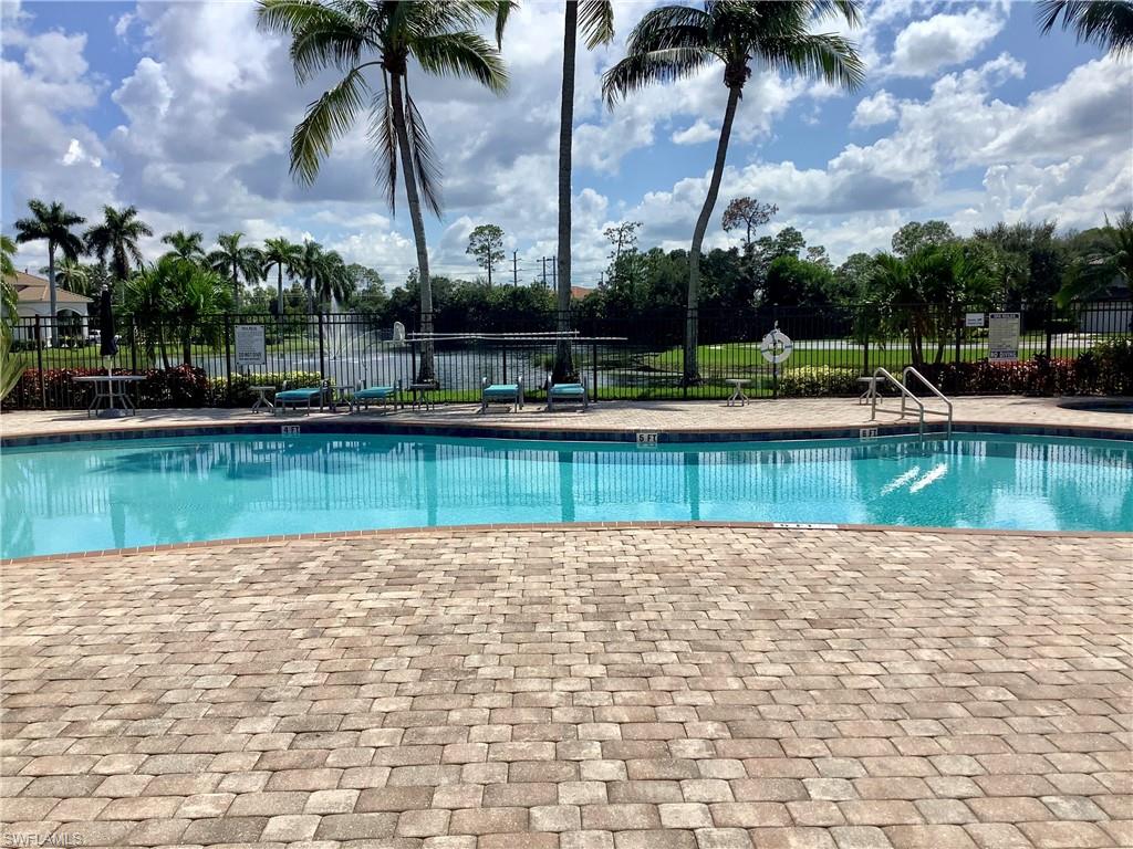 16105 Parque Lane Naples, FL 34110 - Photo 34 of 34 a view of a swimming pool with a chair and palm trees
