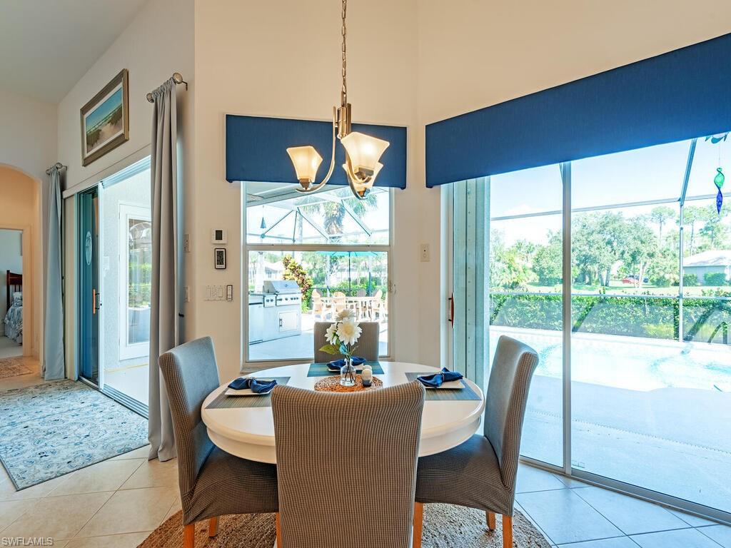 16105 Parque Lane Naples, FL 34110 - Photo 8 of 34 a dining room with furniture a chandelier and wooden floor