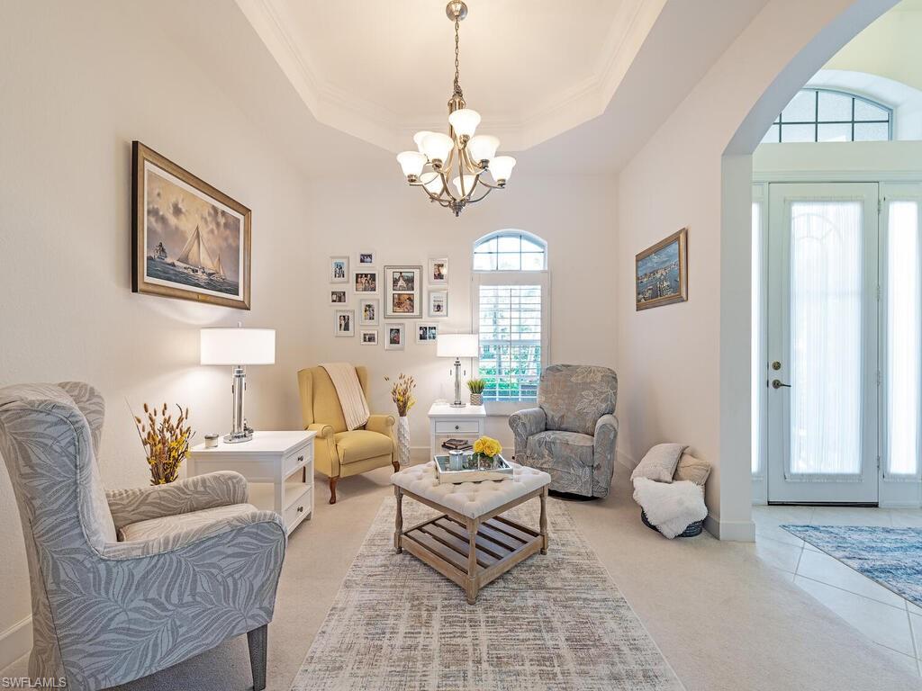16105 Parque Lane Naples, FL 34110 - Photo 9 of 34 a living room with furniture a chandelier and a window