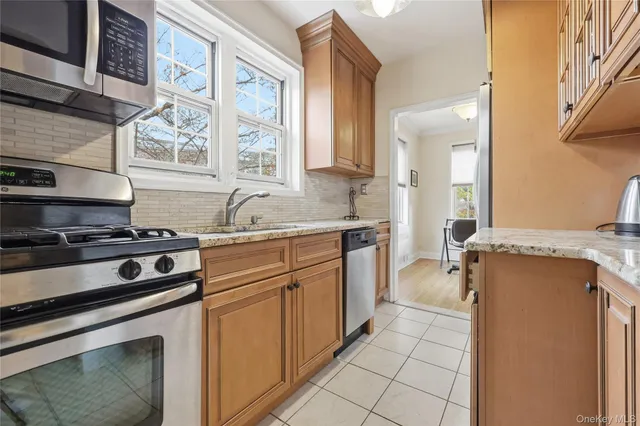 a kitchen with stainless steel appliances granite countertop a sink and a refrigerator