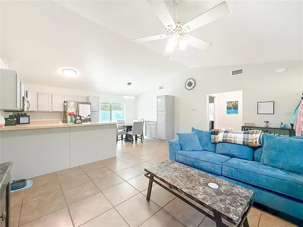 a living room with furniture and a view of kitchen
