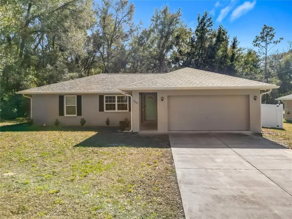 a front view of a house with a yard and trees
