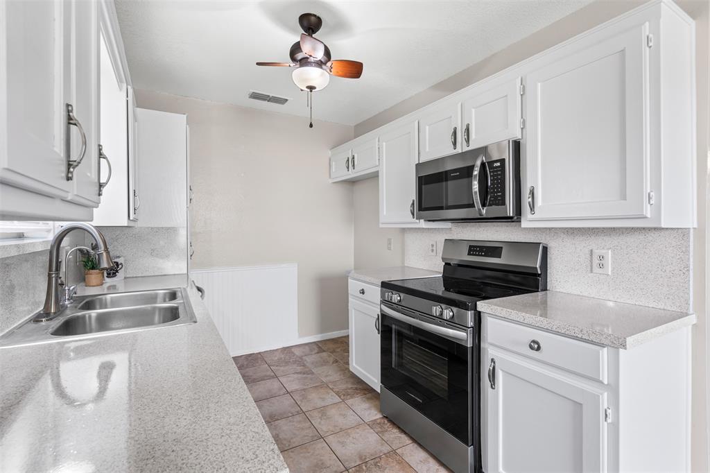 1221 East Fm 4 Cleburne, TX 76031 - Photo 16 of 35 a kitchen with stainless steel appliances a stove sink microwave and cabinets