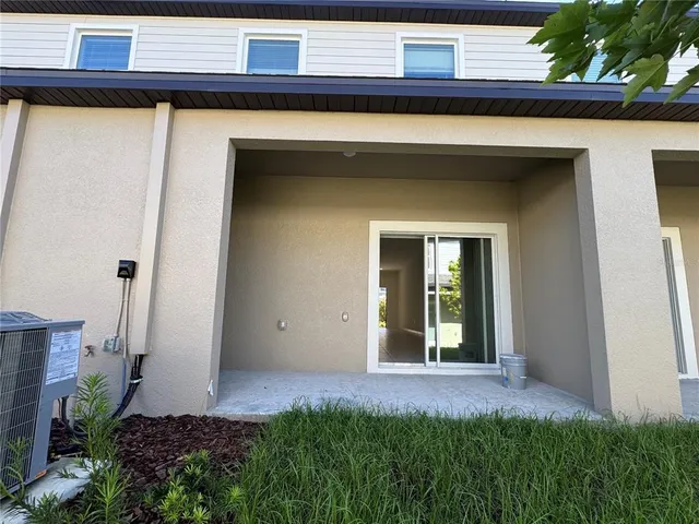 a view of a house with backyard and a tree