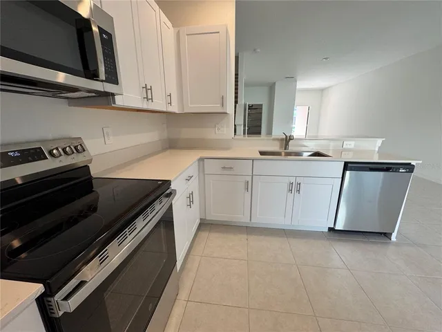 a metallic refrigerator freezer sitting in a kitchen
