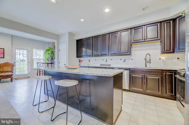a kitchen with granite countertop a sink cabinets and stainless steel appliances