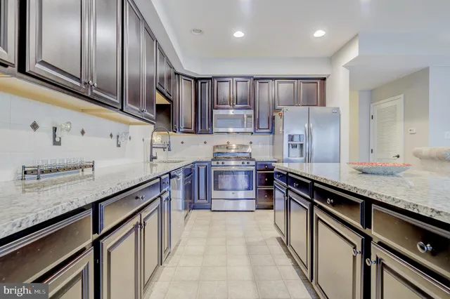 a kitchen with granite countertop stainless steel appliances and wooden cabinets
