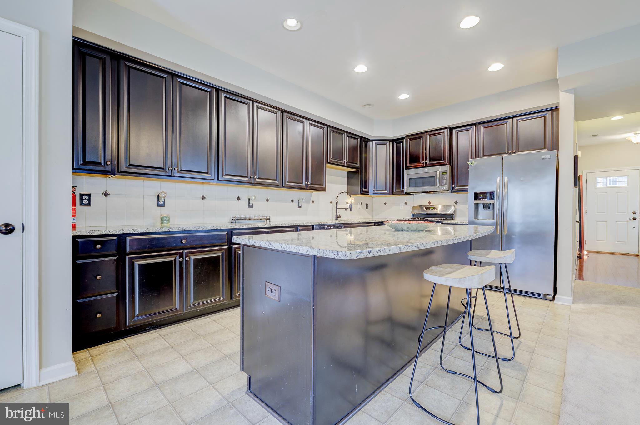 81 Sundance Drive Hamilton, NJ 08619 - Photo 15 of 44 a kitchen with kitchen island granite countertop a stove a sink and a refrigerator