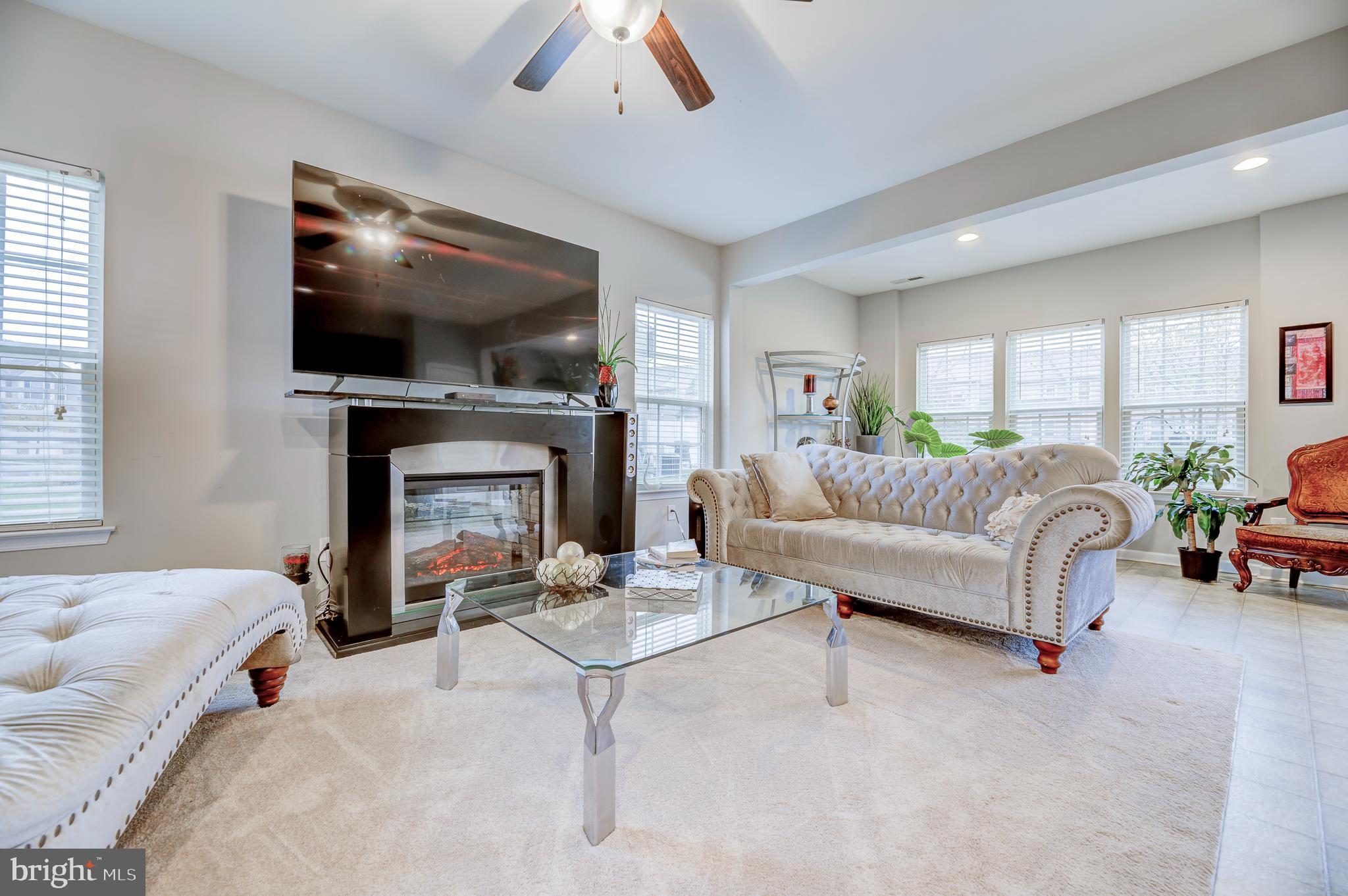 81 Sundance Drive Hamilton, NJ 08619 - Photo 8 of 44 a living room with furniture a flat screen tv and a fireplace