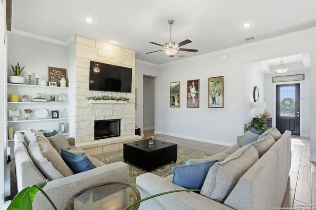 a living room with furniture a flat screen tv and a fireplace