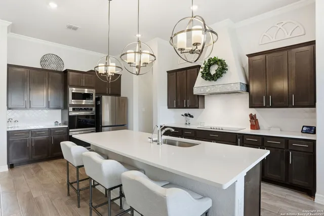 a kitchen with stainless steel appliances granite countertop a sink a microwave oven a stove and a refrigerator