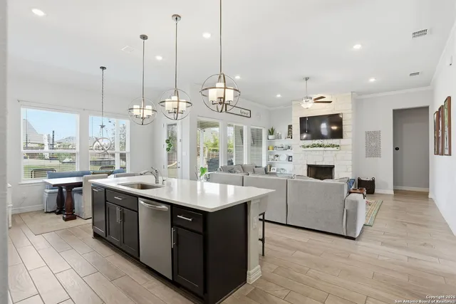 a large kitchen with stainless steel appliances a stove center island a oven a dining table and chairs