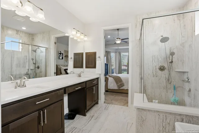 a en suite bathroom with a double vanity sink a large mirror and shower