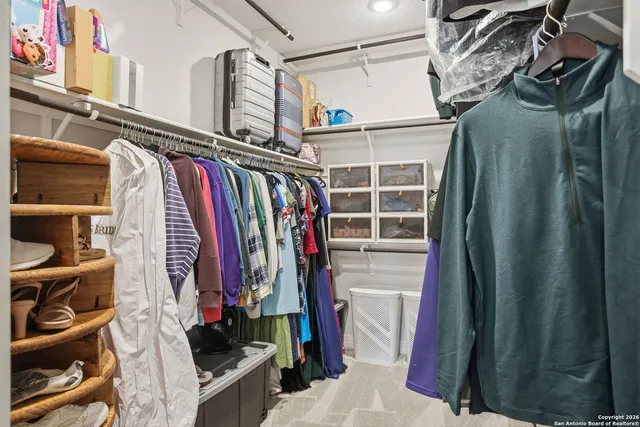a view of walk in closet with clothes and shoes