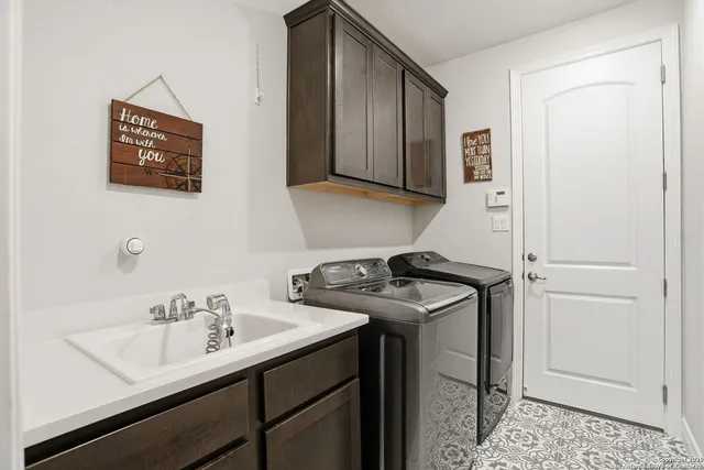 a utility room with sink dryer and washer