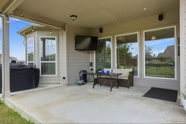 a living room with furniture tv and a large window
