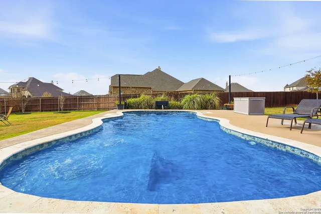 a view of a house with swimming pool and a yard
