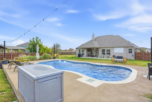 a view of a house with swimming pool and yard