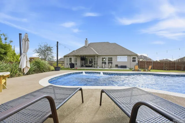 a aerial view of a house with swimming pool and yard