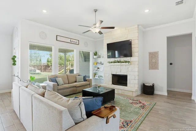 a living room with furniture a flat screen tv and a fireplace