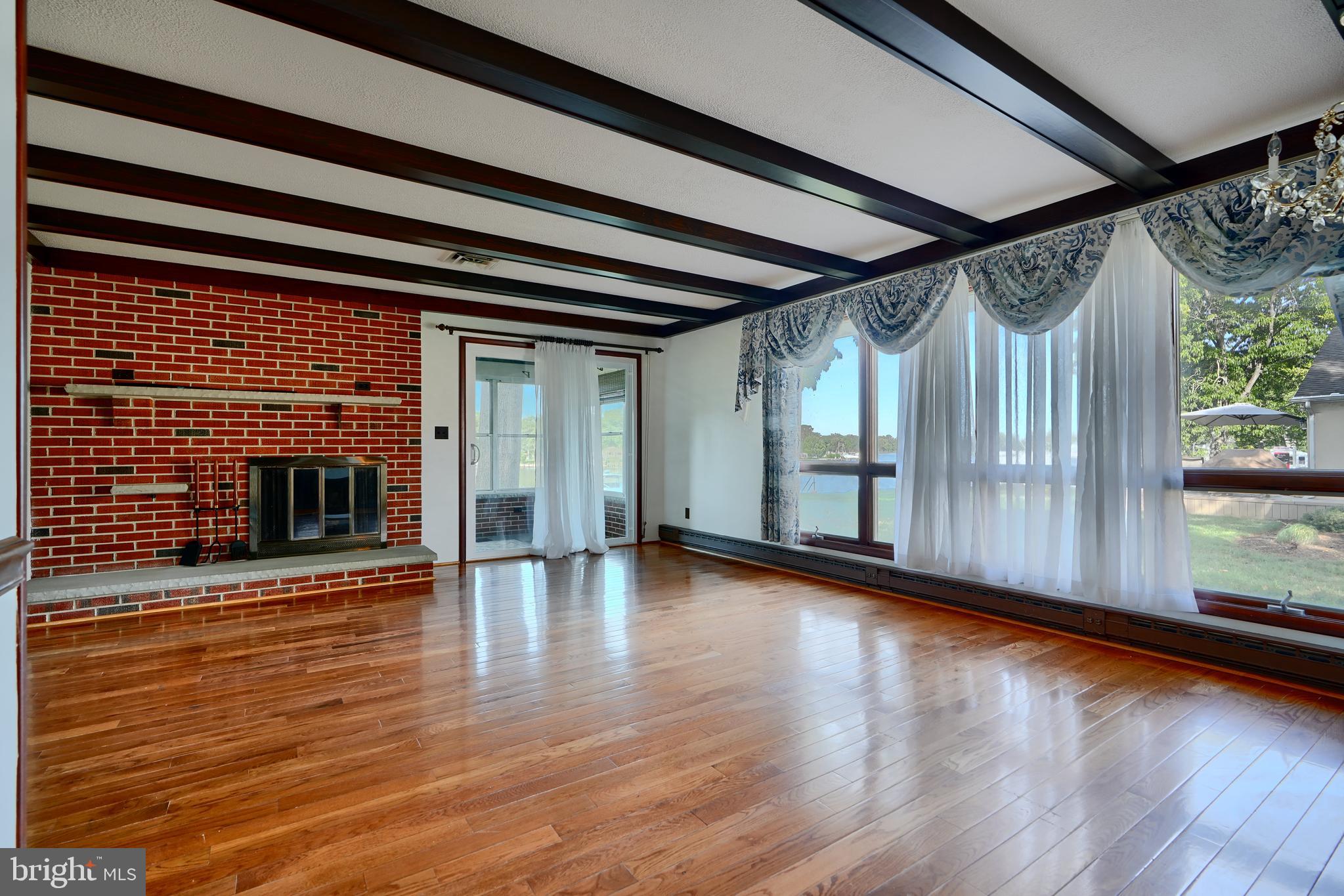 1924 Cedar Road Pasadena, MD 21122 - Photo 6 of 43 a view of an empty room with wooden floor and a window