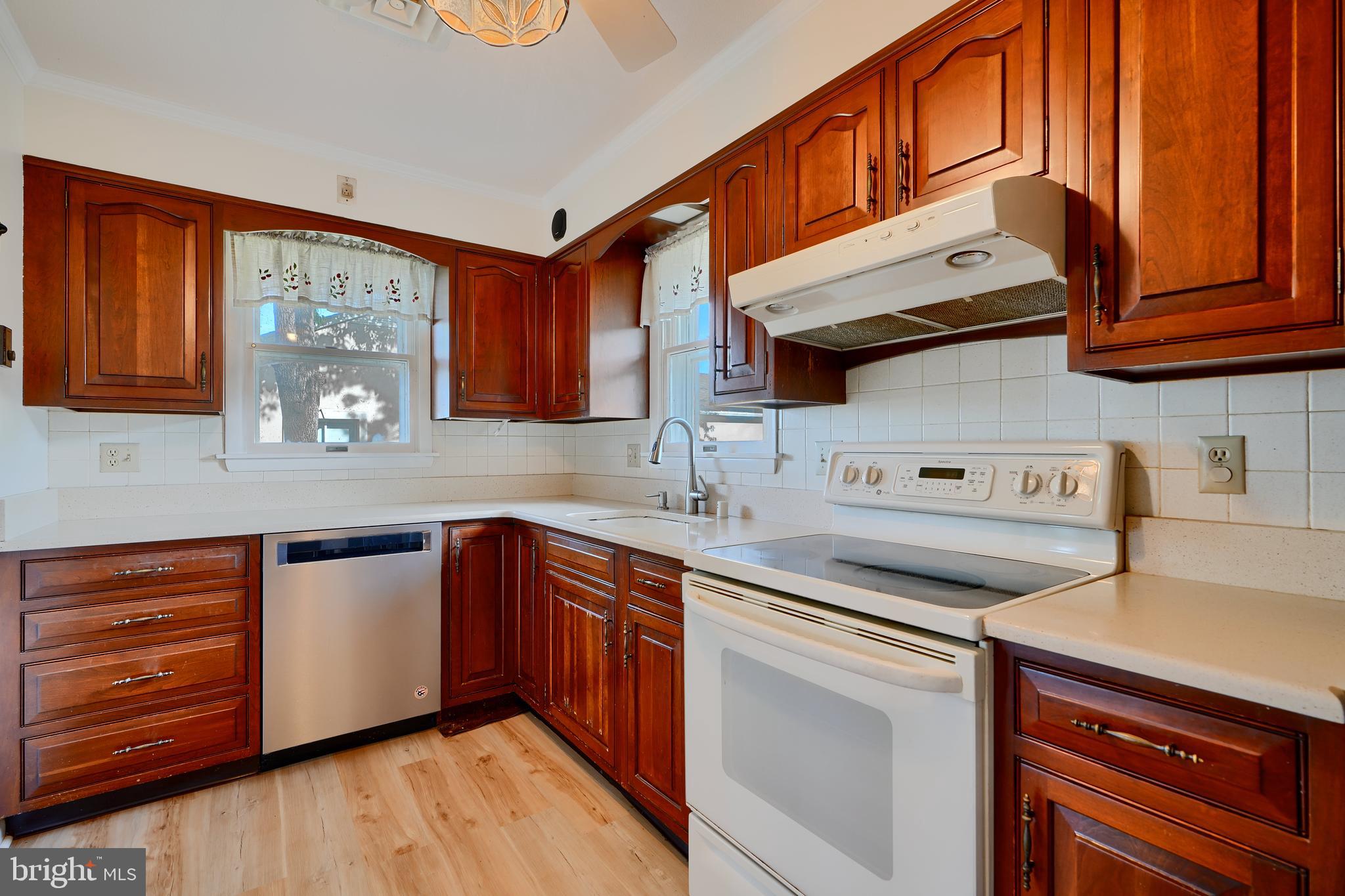 1924 Cedar Road Pasadena, MD 21122 - Photo 10 of 43 a kitchen with stainless steel appliances granite countertop a sink and cabinets with wooden floor