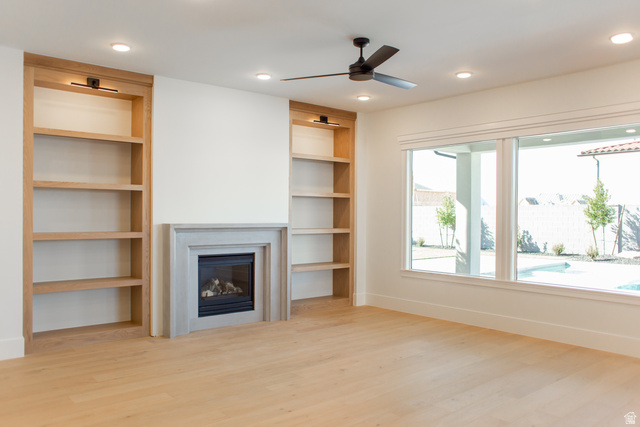 4658 South 380 East Washington, UT 84780 - Photo 2 of 10 Unfurnished living room featuring light wood-style flooring, built in features, ceiling fan, a glass covered fireplace, and recessed lighting