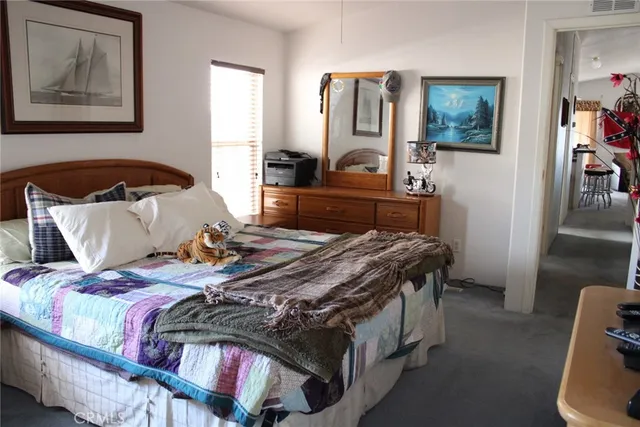 a bedroom with bed and wooden floor