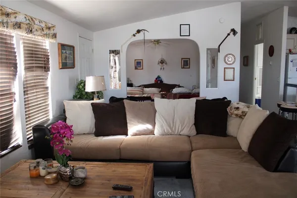 a living room with furniture a chandelier and a window