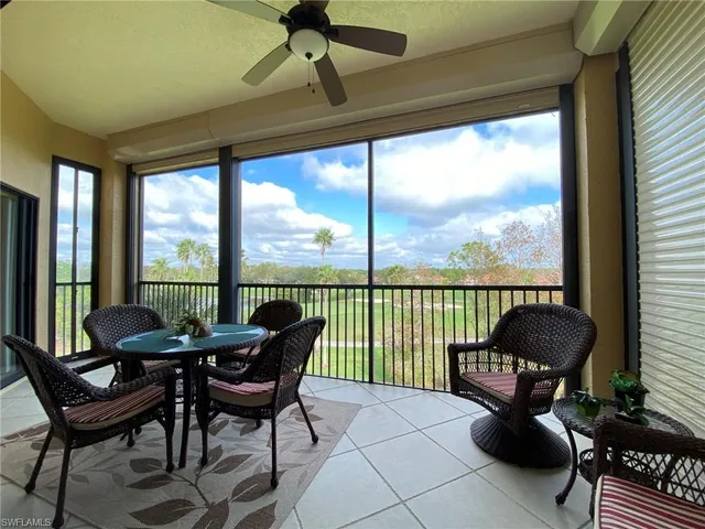 a living room with furniture and a floor to ceiling window