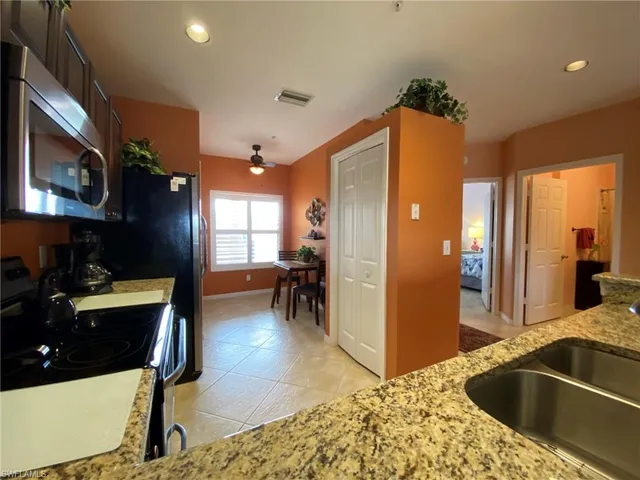 a kitchen with sink refrigerator and cabinets