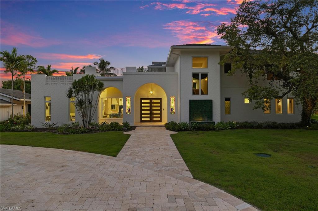 111 Caribbean Road Naples, FL 34108 - Photo 47 of 50 a view of a white house with a big yard and potted plants