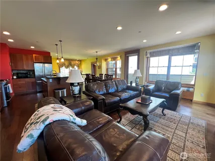 a living room with furniture kitchen view and a large window