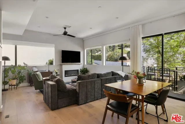 a living room with furniture a flat screen tv and a large window