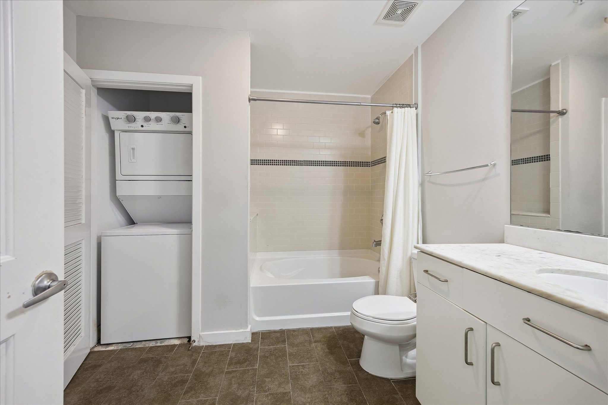 5925 Almeda Road, Unit 10913 Houston, TX 77004 - Photo 8 of 31 Convenient in-unit stacked washer and dryer are tucked neatly beside the bathroom, offering everyday functionality without sacrificing space.