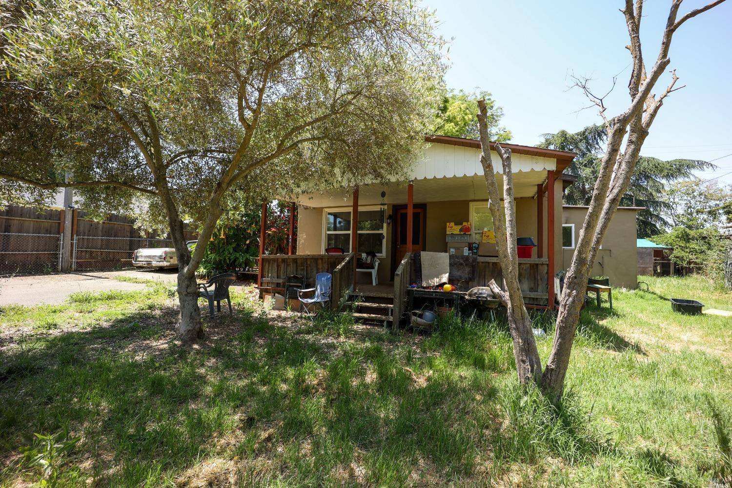 a view of a house with backyard and a tree