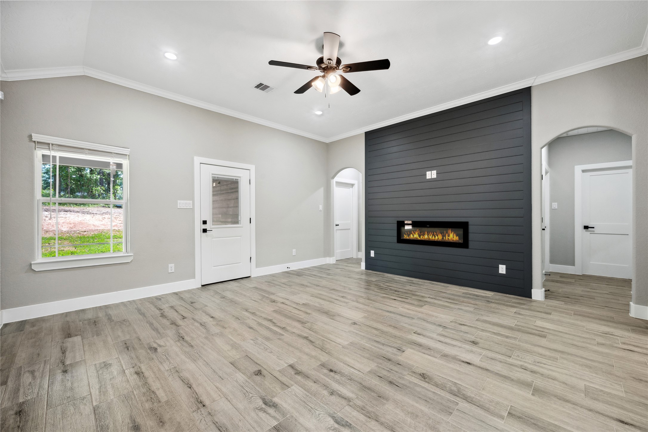 139 Popular Street Onalaska, TX 77360 - Photo 8 of 27 Spacious living room features a beautiful accent wall with electric fireplace. Split bedroom plan with door to right leading to guest bedrooms and door to left leading to Primary suite.