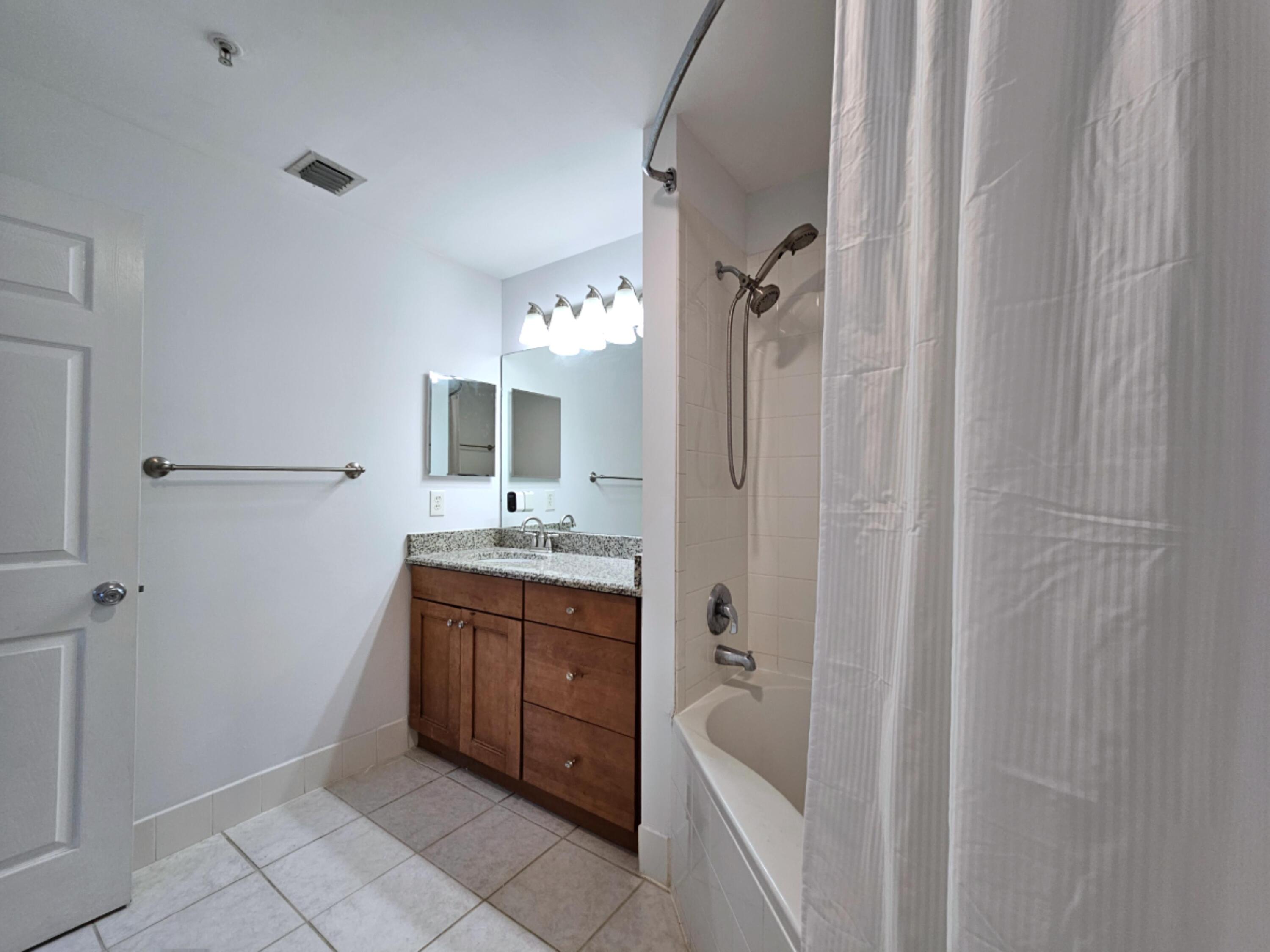 2020 Greenview Shores Boulevard, Unit 108 Wellington, FL 33414 - Photo 14 of 25 a bathroom with a tub sink vanity granite and a mirror