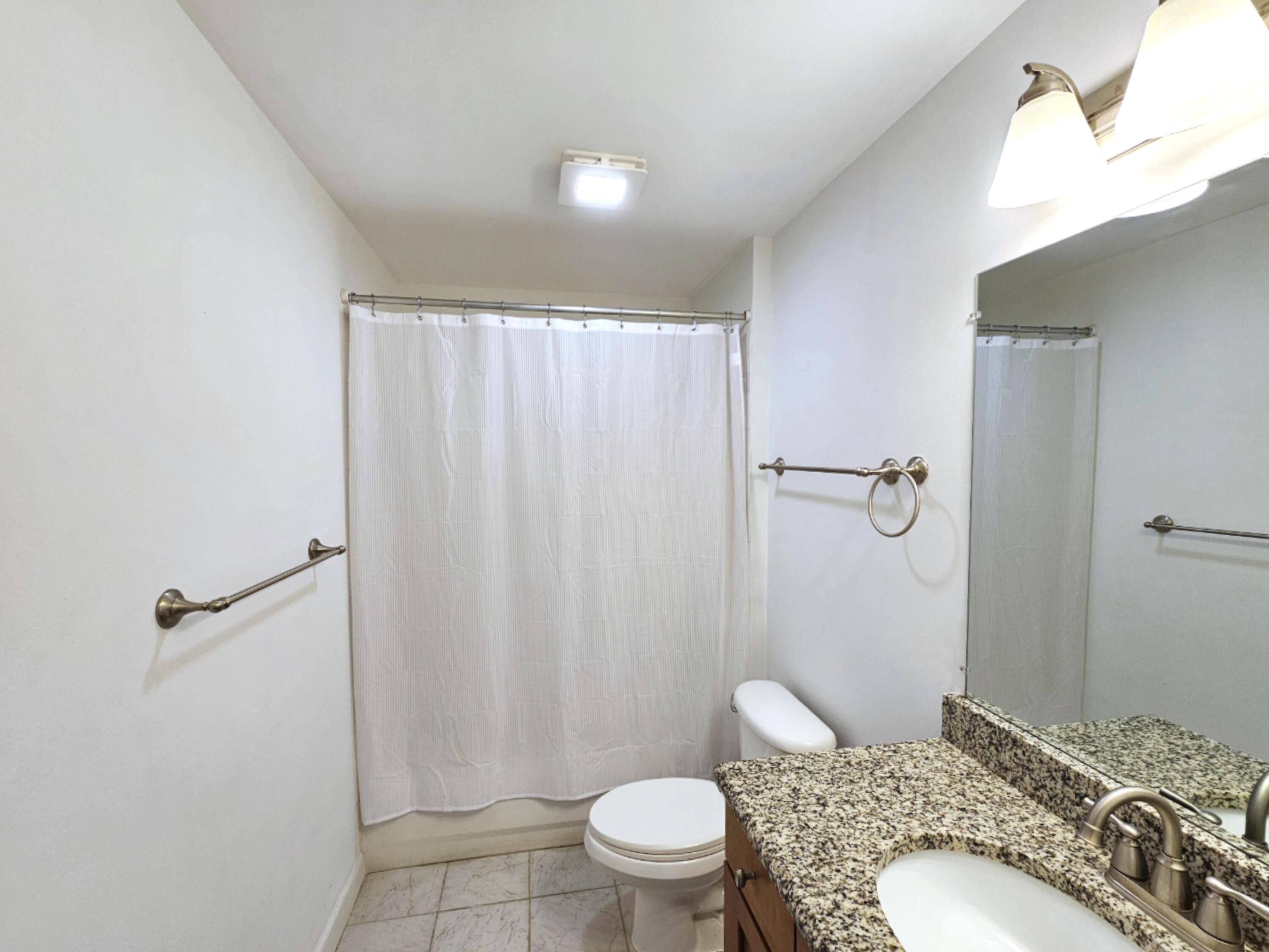 2020 Greenview Shores Boulevard, Unit 108 Wellington, FL 33414 - Photo 16 of 25 a bathroom with a sink toilet and shower
